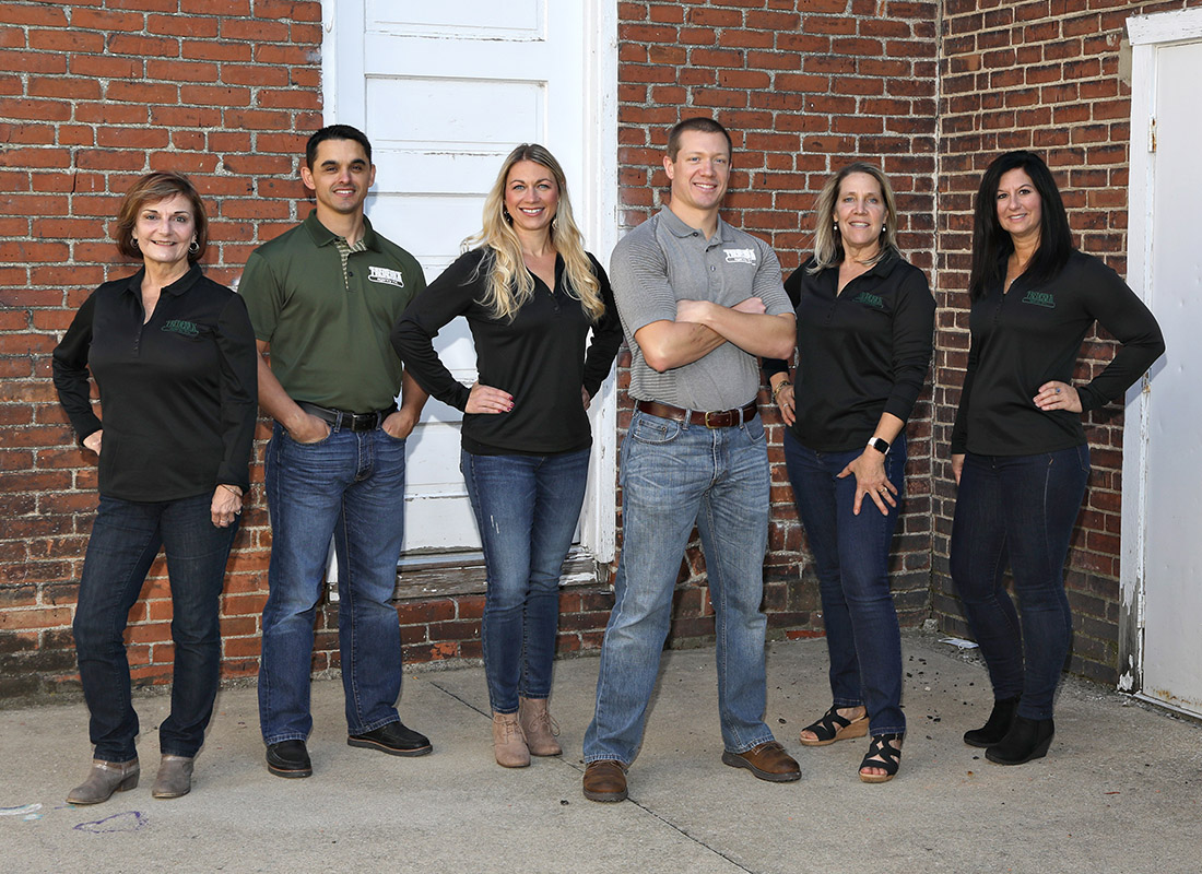 Agency Photo - Frederick Agency Inc. Team Standing Together in Front on a Brick Wall Outside